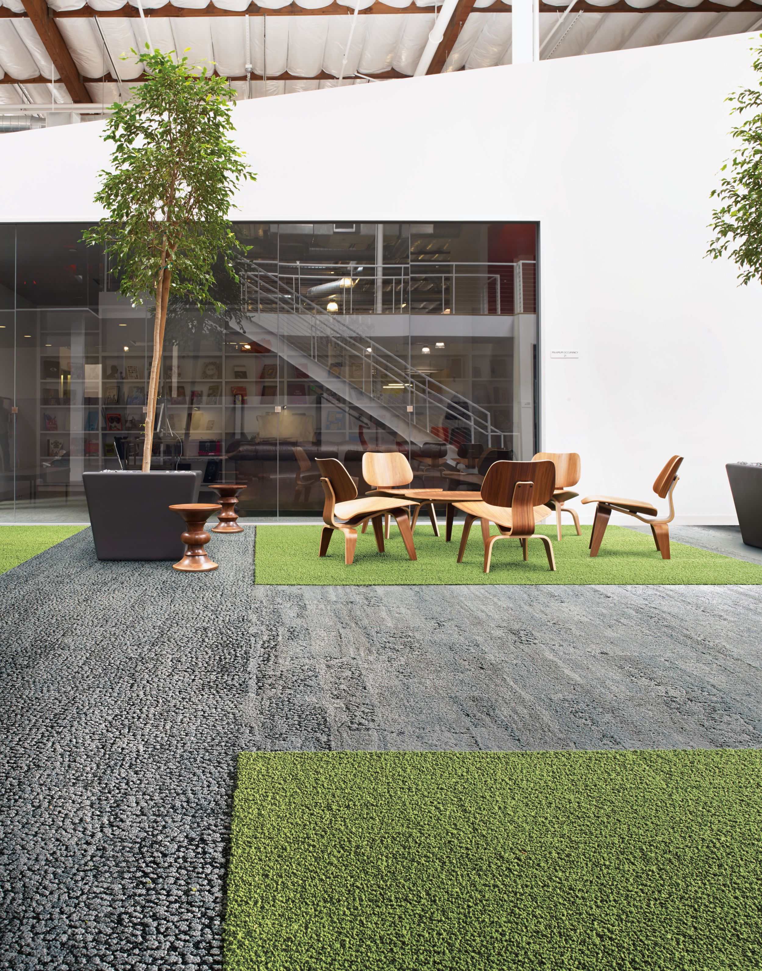 image Interface HN810, HN830, HN840 and HN850 plank carpet tiles in open area with wood table and chairs and stairwell in the background numéro 4